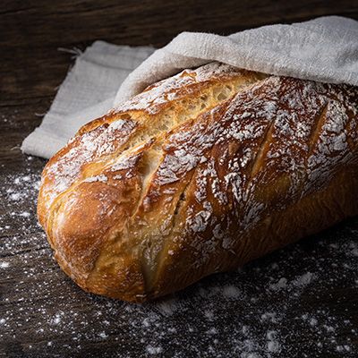 a farmhouse loaf of bread covered with a cloth